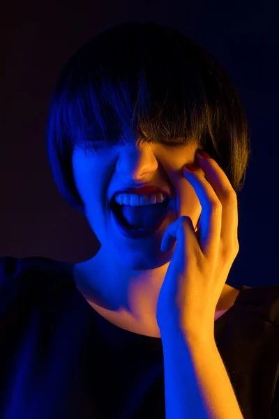 Mujer feliz en una peluca en el estudio sobre un fondo oscuro —  Fotos de Stock