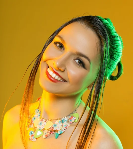 Beautiful woman with jewelry on a yellow background in the studio — Stock Photo, Image