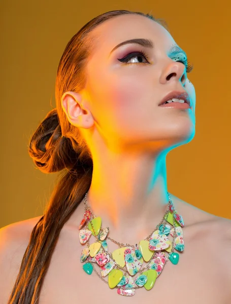 Beautiful girl with makeup and jewellery in studio shot — Stock Photo, Image