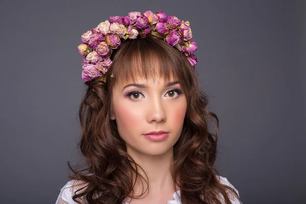 Retrato de una mujer glamorosa sensual hermosa en una blusa blanca con una corona de flores, en el estudio sobre un fondo oscuro, de cerca —  Fotos de Stock