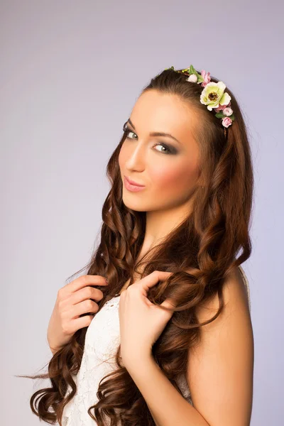 Mulher com cabelos longos encaracolados e uma coroa de flores — Fotografia de Stock