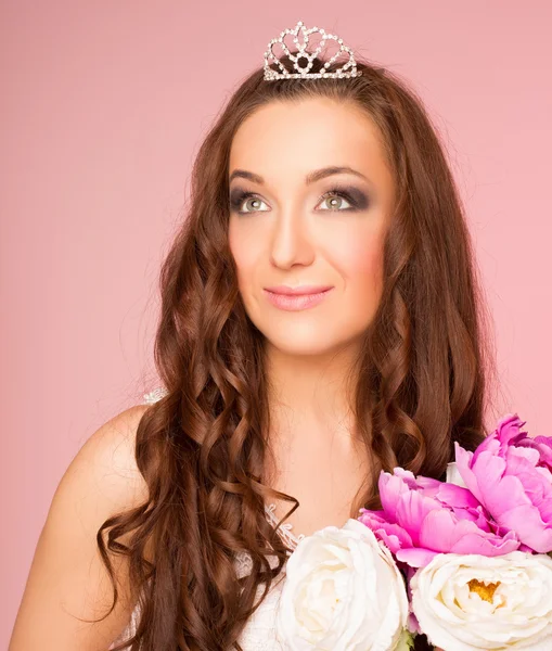 Menina com estilo de cabelo olhando para o lado. coroa de cabelo. em um fundo rosa — Fotografia de Stock