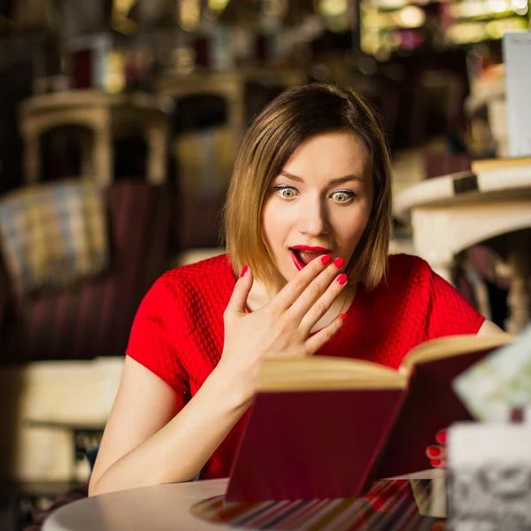 Überraschte Frau liest Buch — Stockfoto