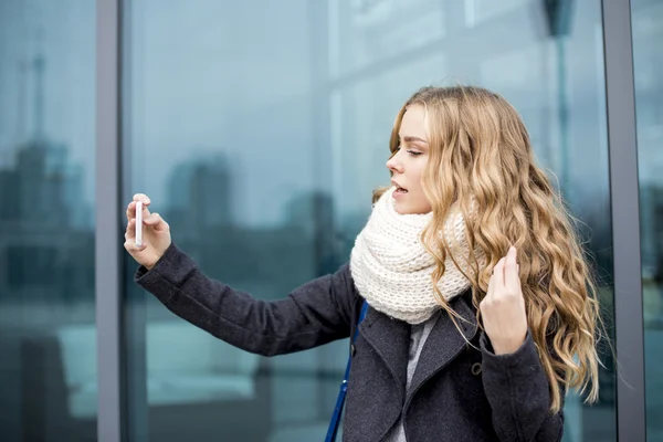 Trendy jonge vrouw in zwarte jas en witte sjaal — Stockfoto