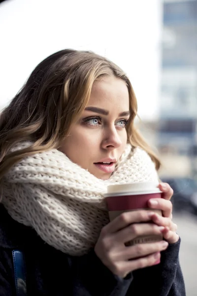 Привлекательная блондинка с вьющимися волосами пьет кофе на открытом воздухе — стоковое фото