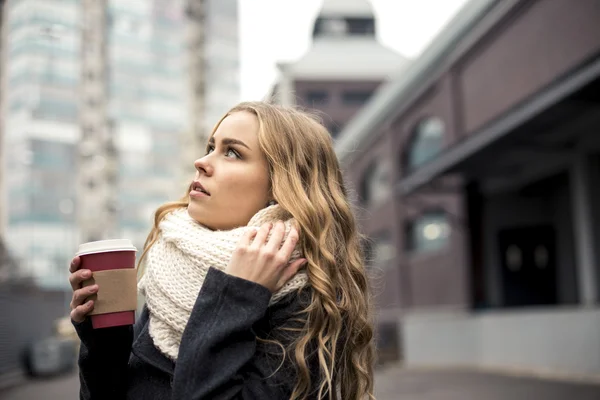 Aantrekkelijke vrouw lopen op de straat met warme koffie — Stockfoto