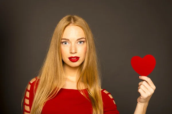 Red-haired woman holding a red heart in her hand — Stock Photo, Image