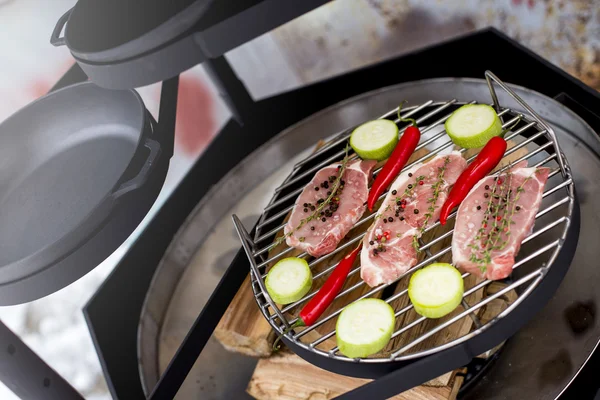 Raw meat on the grill with the barbecue zucchini and red pepper — Stock Photo, Image