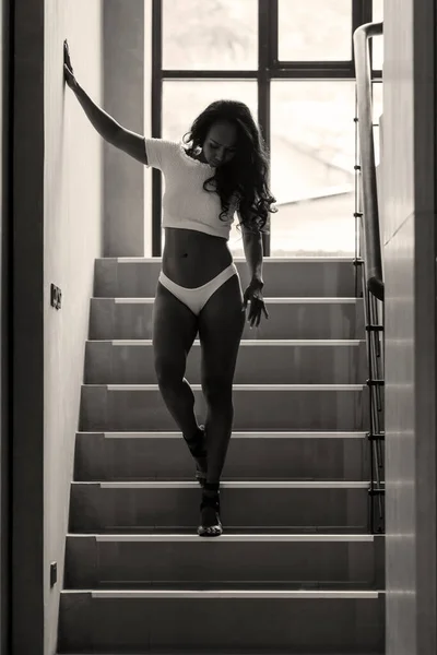 Young asian sportive woman in bikini walking on stairs. Sepia image