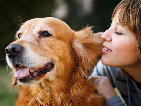 Girl whispering in her dog's ear — Stock Photo, Image