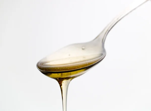 Cuchara con miel líquida — Foto de Stock
