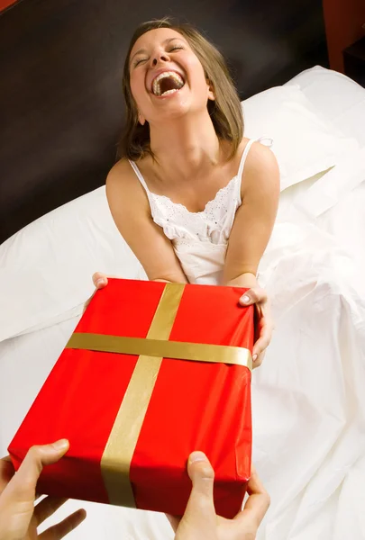 Mulher na cama com presente — Fotografia de Stock