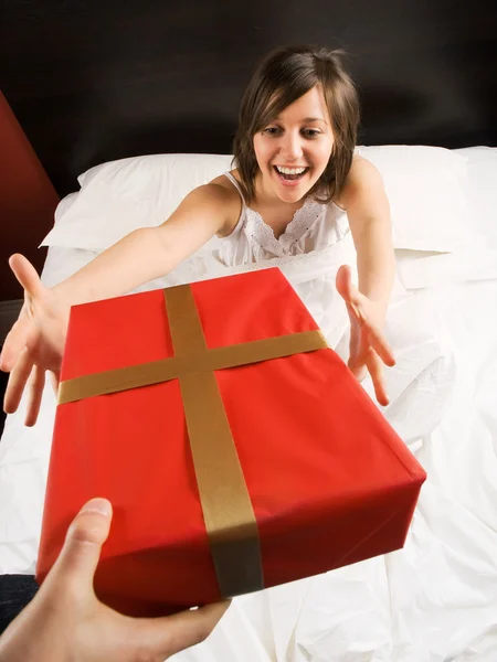 Woman in bed with present — Stock Photo, Image