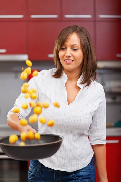 Young woman frying potatoes — Stock Photo, Image