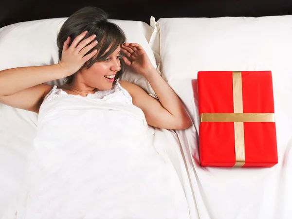 Mulher na cama com presente — Fotografia de Stock