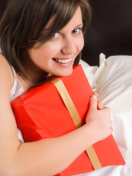 Mulher na cama com presente — Fotografia de Stock