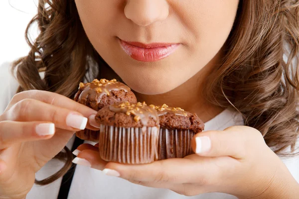 Woman eating chocolate muffins — Stock Photo, Image