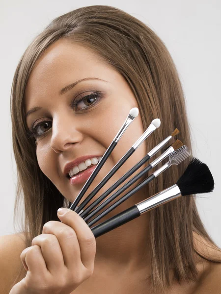 Mujer joven aplicando maquillaje — Foto de Stock