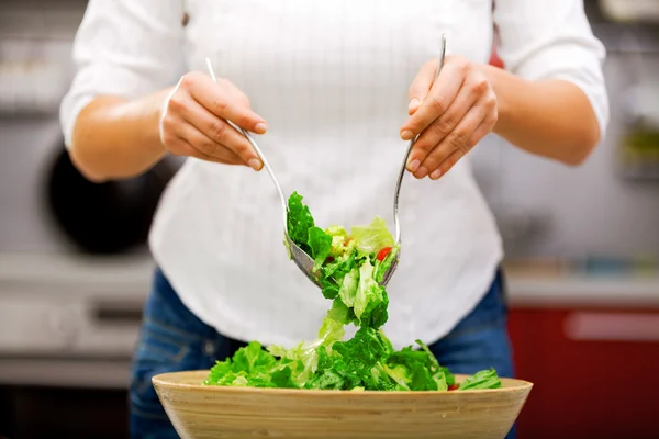 Jonge vrouw maken salade — Stockfoto