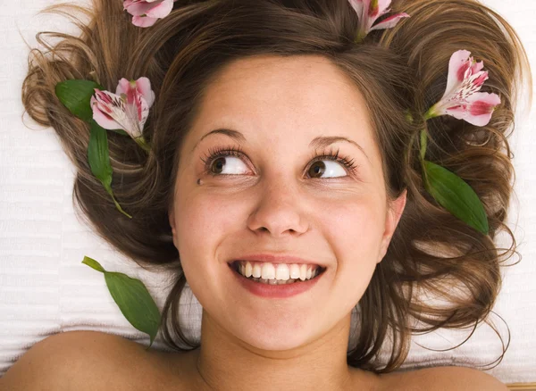 Young woman lying with flowers — Stock Photo, Image
