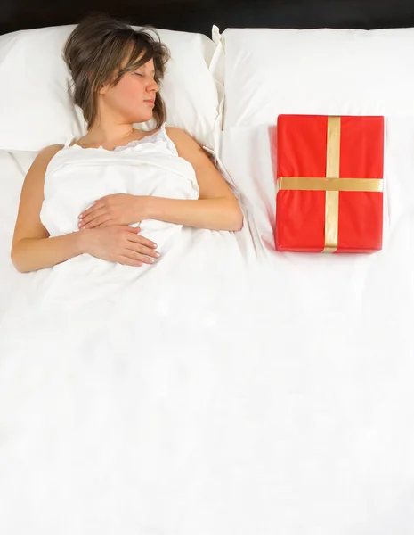 Žena v posteli a s dárek — Stock fotografie