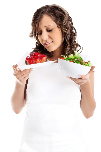 Vrouw kiezen snoepjes of gezond eten — Stockfoto