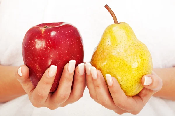 Woman holding apple and pear — Stock Photo, Image