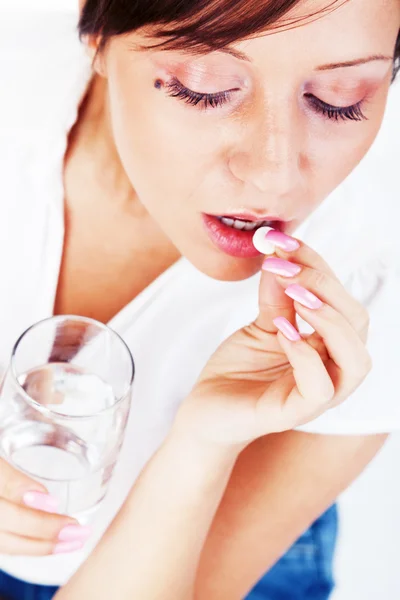 Mujer joven tomando píldora — Foto de Stock