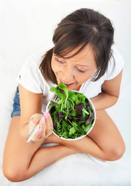 Mujer joven comiendo ensalada — Foto de Stock