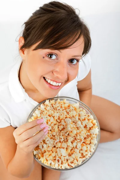 Mujer joven comiendo palomitas de maíz — Foto de Stock