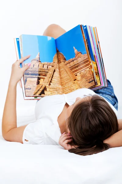 Mujer joven leyendo revista de viajes —  Fotos de Stock