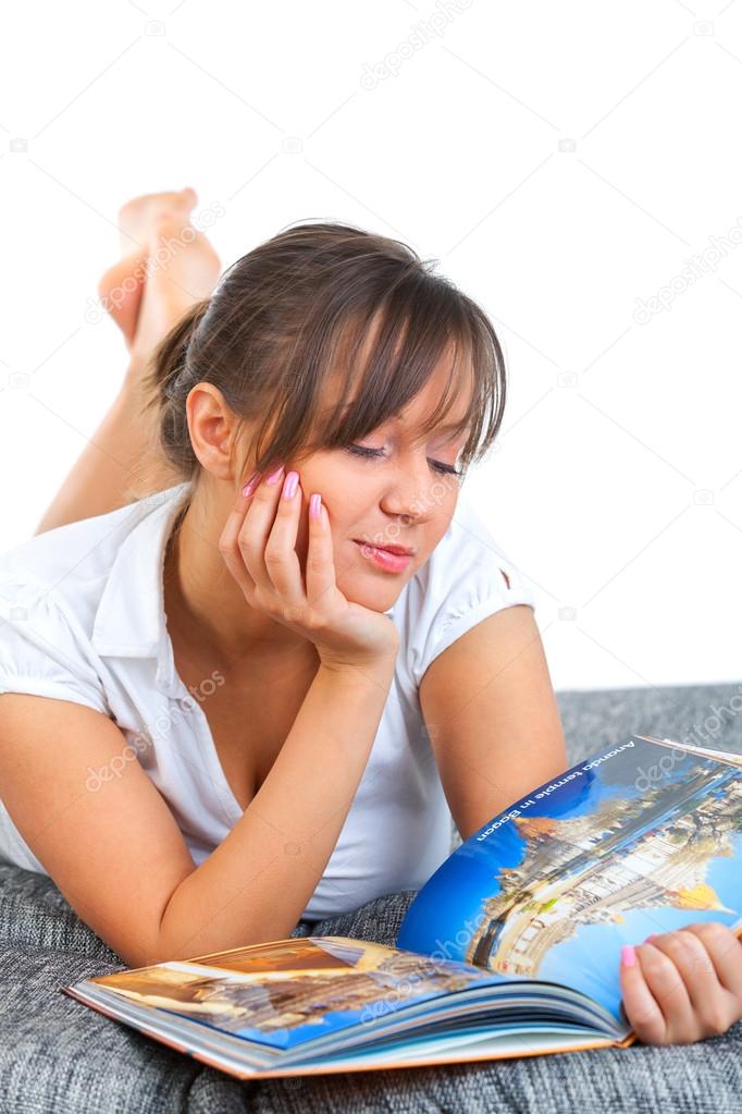 Young woman reading travel magazine