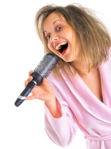 Kobieta w housecoat śpiewu z szczotka do włosów — Zdjęcie stockowe