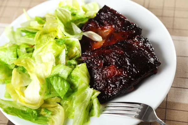 Revbensspjäll med sallad — Stockfoto