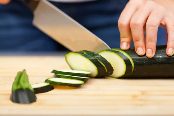 Young woman cutting zucchini Stock Photo