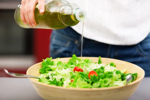 Jonge vrouw maken salade — Stockfoto