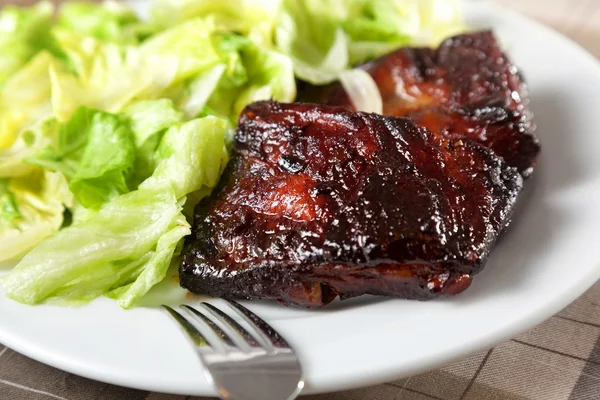 Revbensspjäll med sallad — Stockfoto