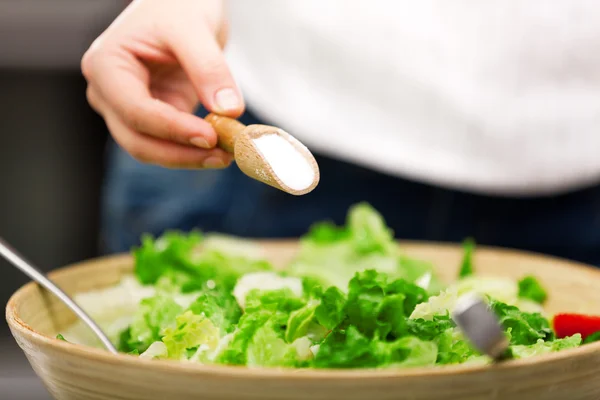 Jonge vrouw maken salade — Stockfoto