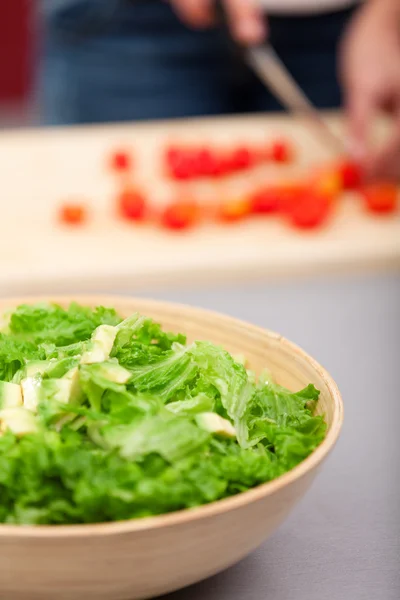 Jonge vrouw maken salade — Stockfoto