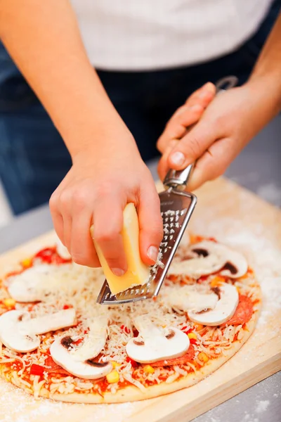 Nuori nainen valmistelee pizzaa — kuvapankkivalokuva