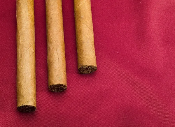 Three Cigars on red — Stock Photo, Image