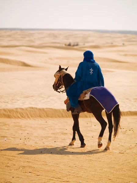 Man paardrijden paard in woestijn — Stockfoto