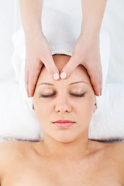 Jovem mulher fazendo massagem — Fotografia de Stock