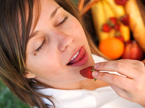Femme mangeant des fraises à l'extérieur — Photo
