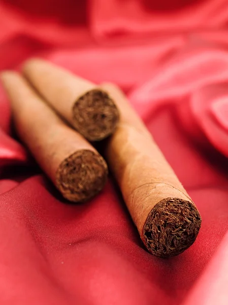 Three Cigars on red satin — Stock Photo, Image