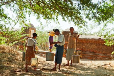 women collecting water in a buckets, Myanmar clipart