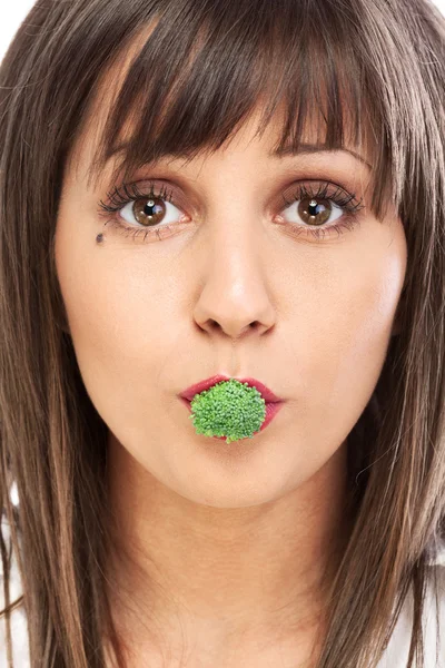 Jeune femme mangeant du brocoli — Photo