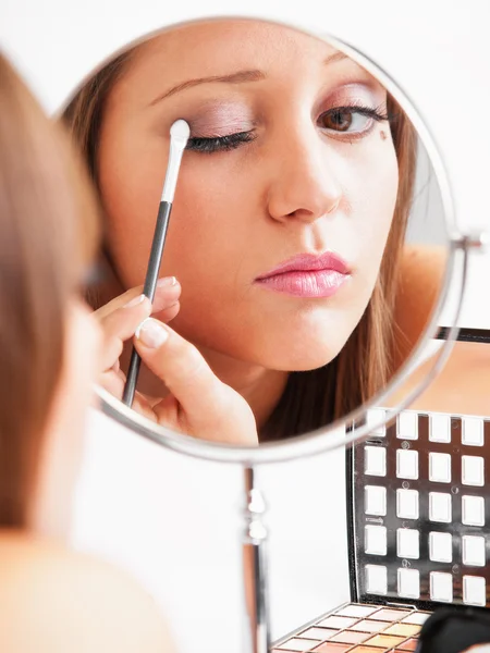 Applicare il make-up sul viso della giovane donna — Foto Stock