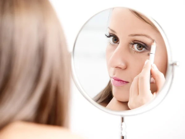 Applicare il make-up sul viso della giovane donna — Foto Stock