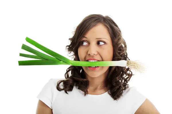 Mujer joven comiendo puerro fresco —  Fotos de Stock